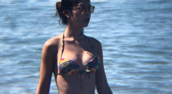 Asian TS girl in bikini wading in the sea.